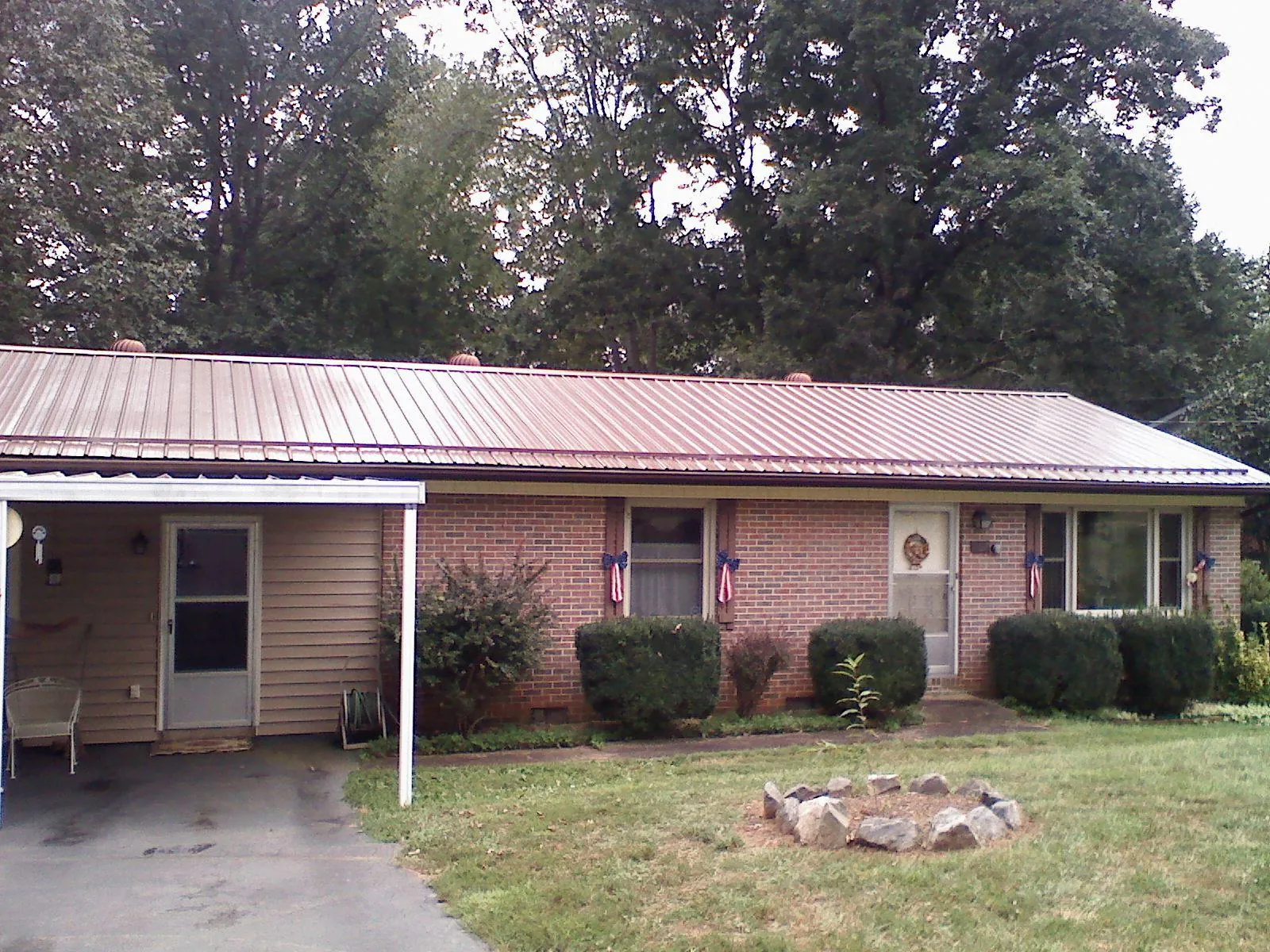 Bronze metal roof and carport on a brick ranch home — Roof Repair work by our crew in Sugar Hill